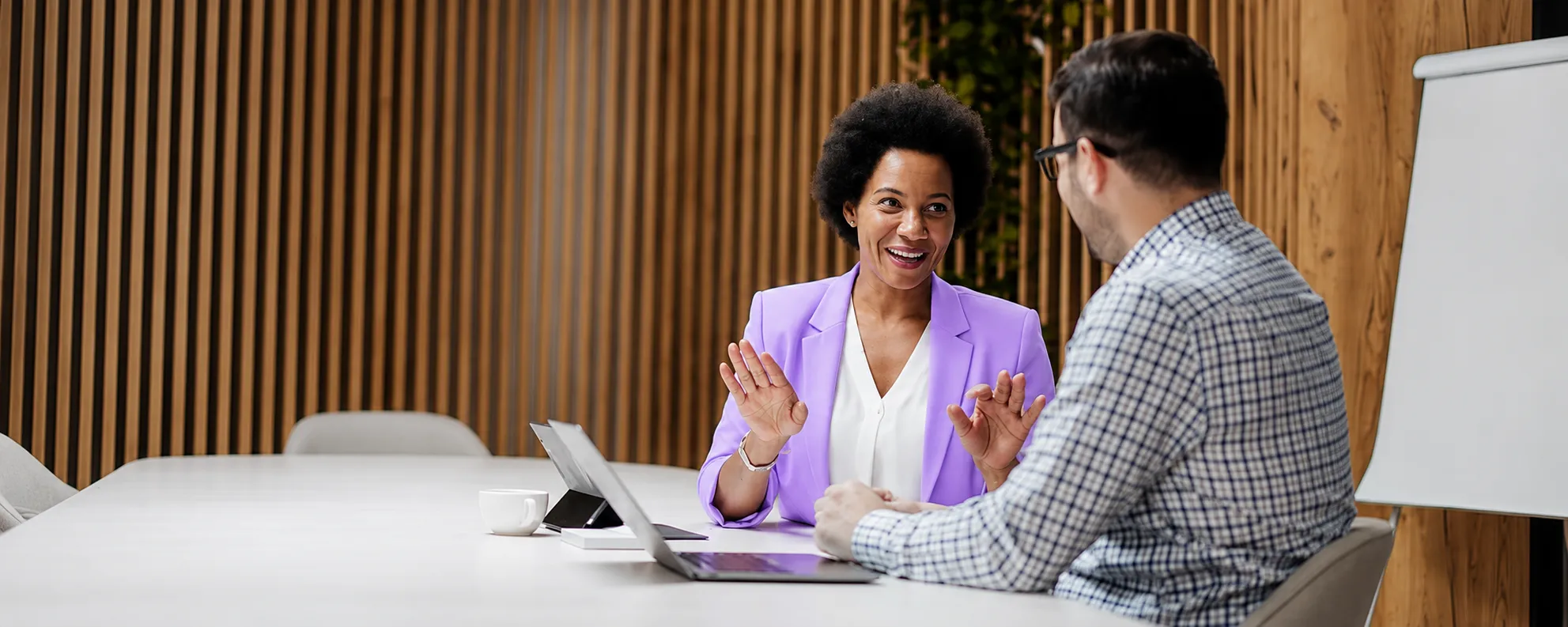 Two colleagues talking through a control review across a meeting table