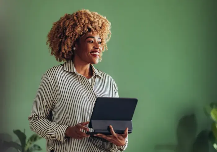 A colleague holding a tablet, smiling to camera