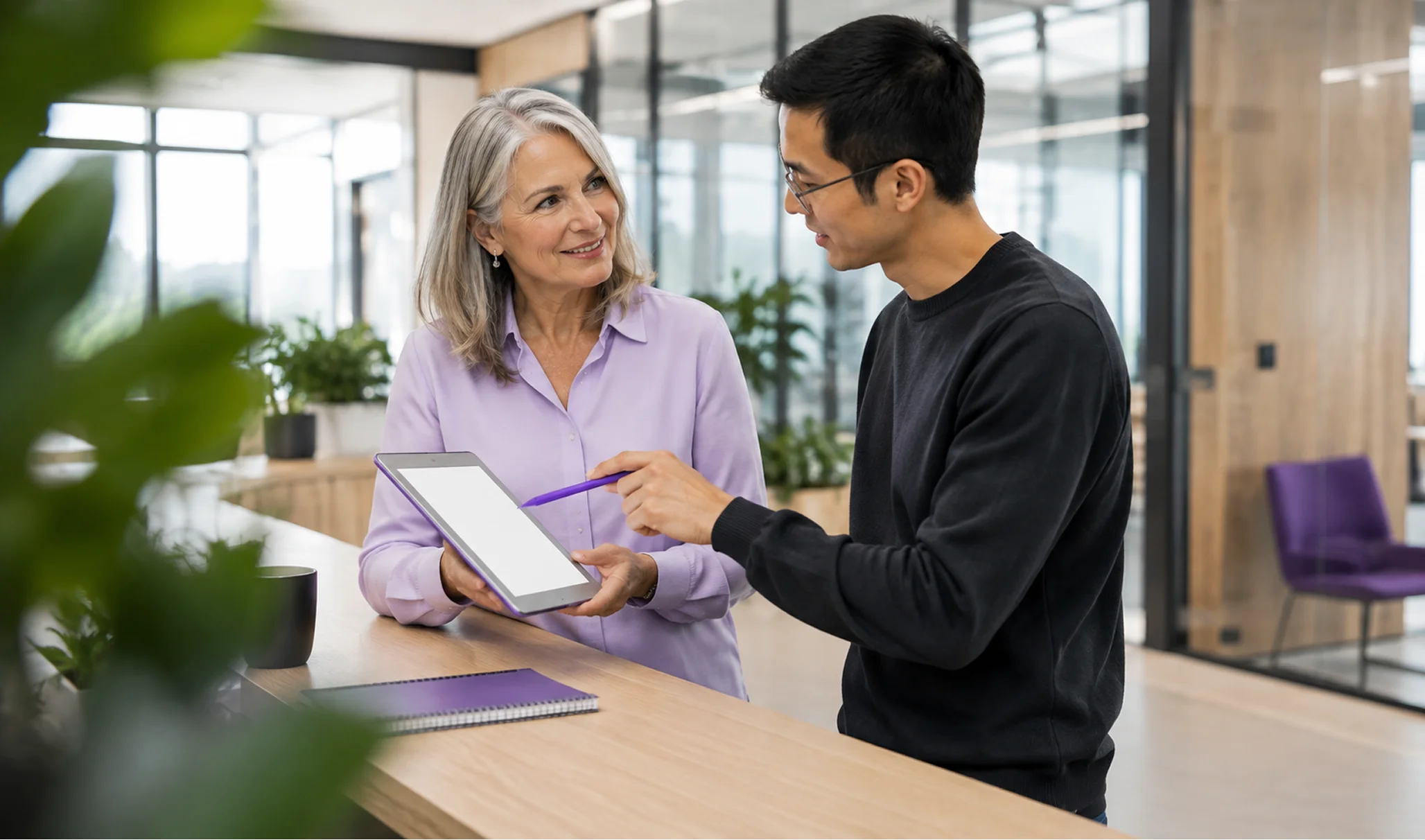 Two colleagues reviewing a loan file together at a laptop